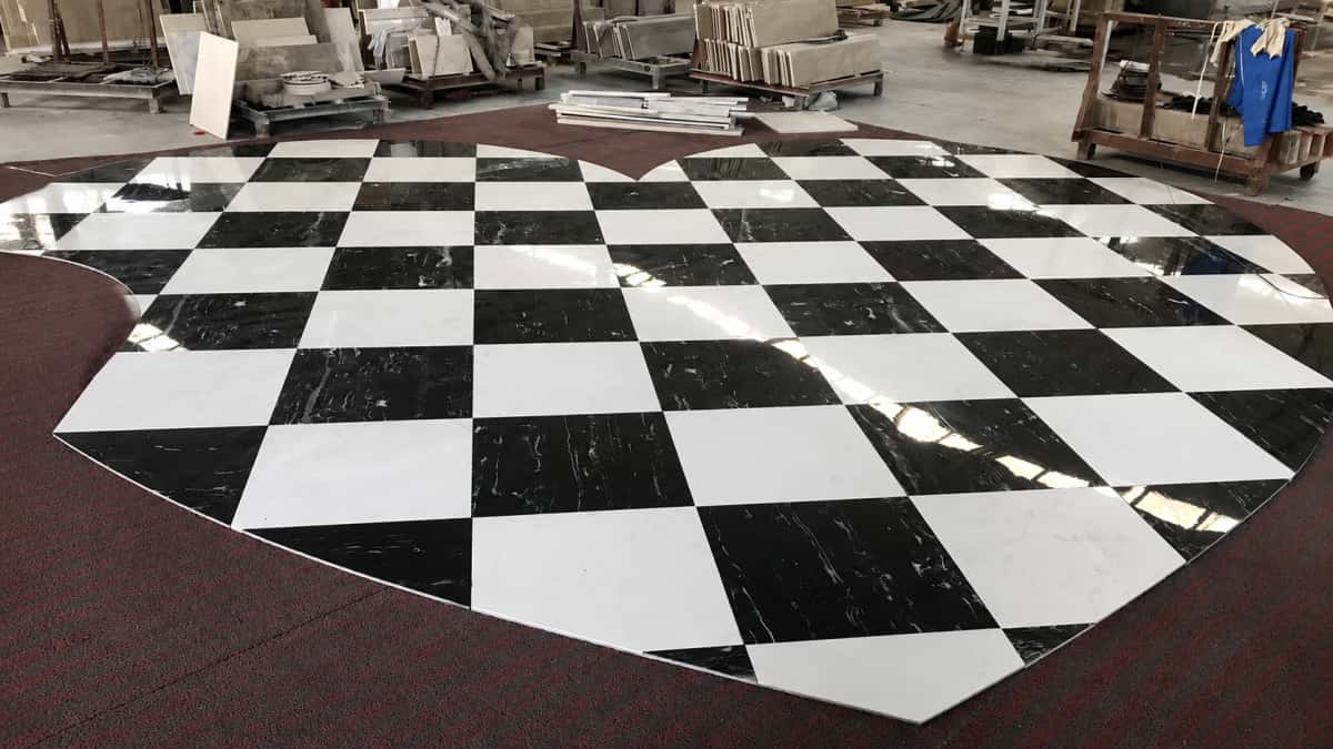 Factory dry layout of heart-shaped black and white marble floor inlay for hotel project