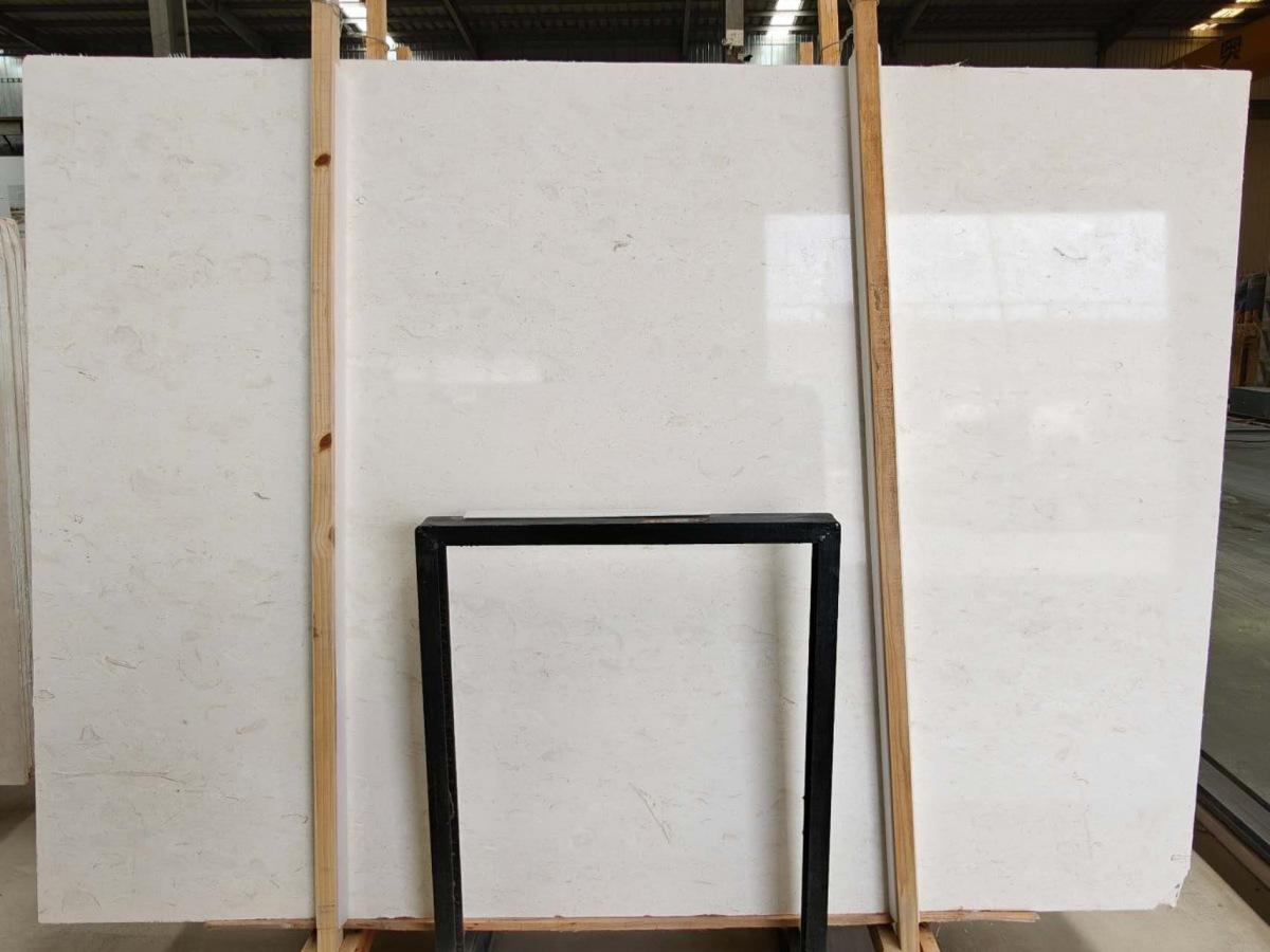 Full Moon Beige limestone slab showing a warm light beige background and natural fossil variation
