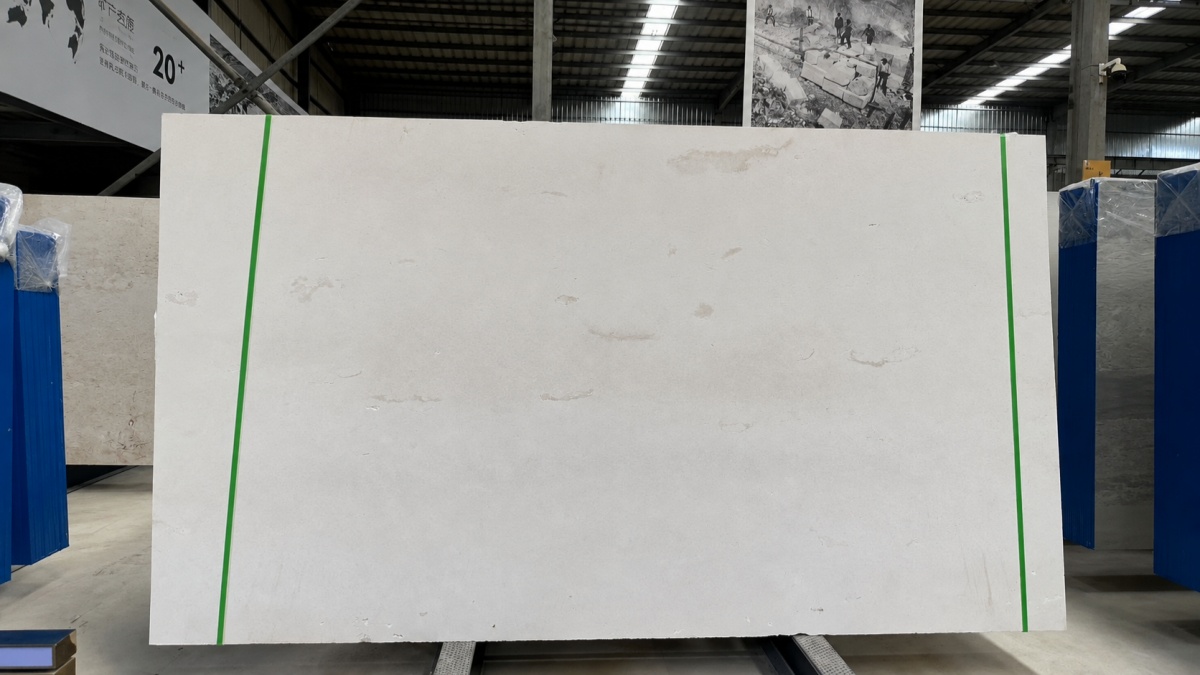 benin-white-limestone-factory-full-slab Natural white limestone slab on a support rack in a stone factory